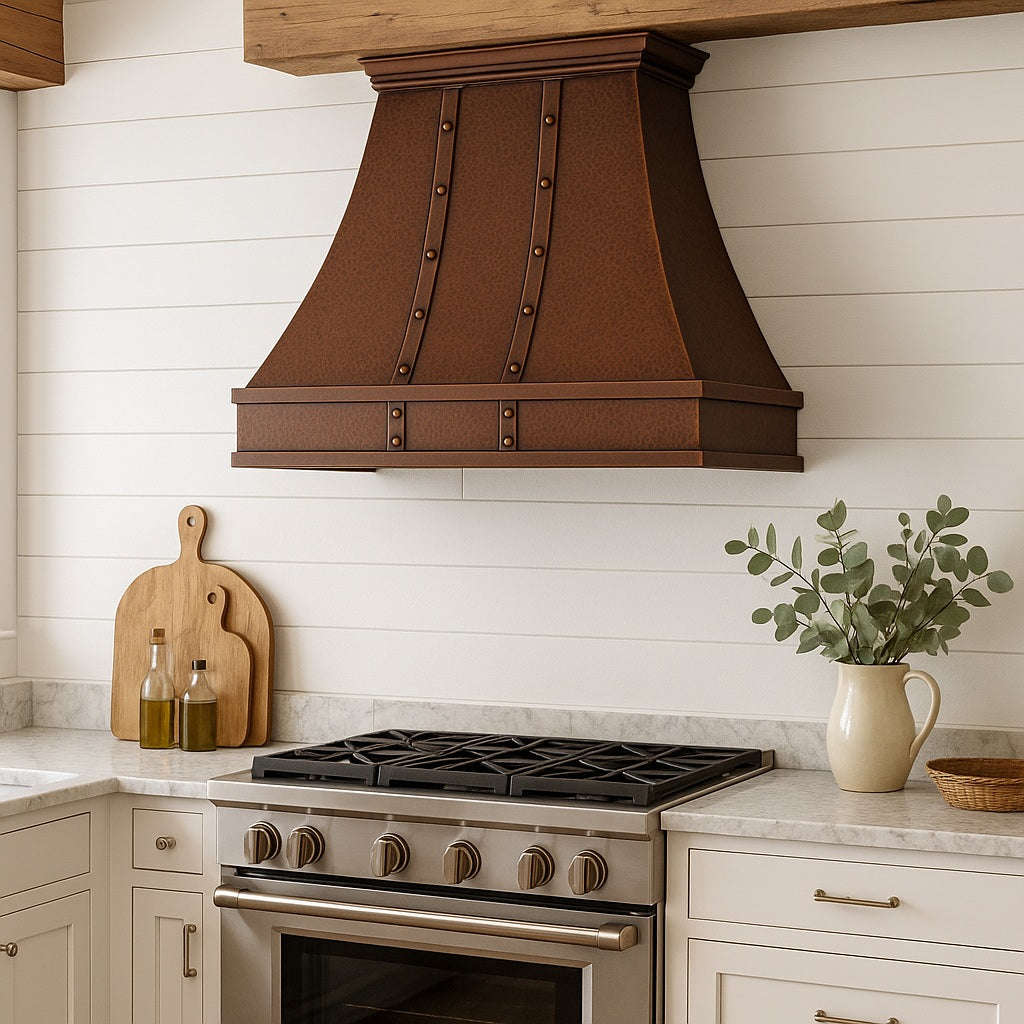 Hammered copper range hood with vertical riveted straps in a rustic farmhouse style kitchen