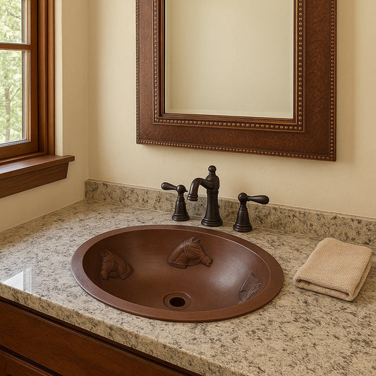 Large custom hammered oval copper drop in sink with horse head reliefs in a bathroom
