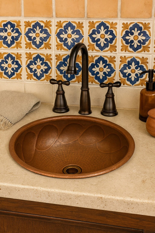 Custom round copper drop-in sink with braided relief in a hacienda style bathroom with talavera tiles