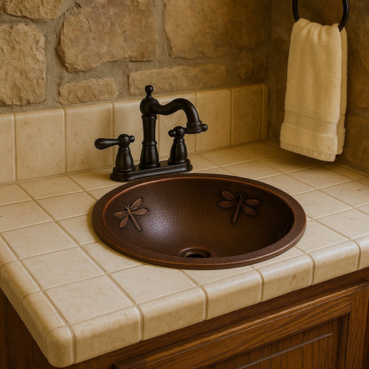 Custom round copper drop in sink with dragonfly reliefs in lodge bathroom, stone wall backdrop and deep basin with raised motifs