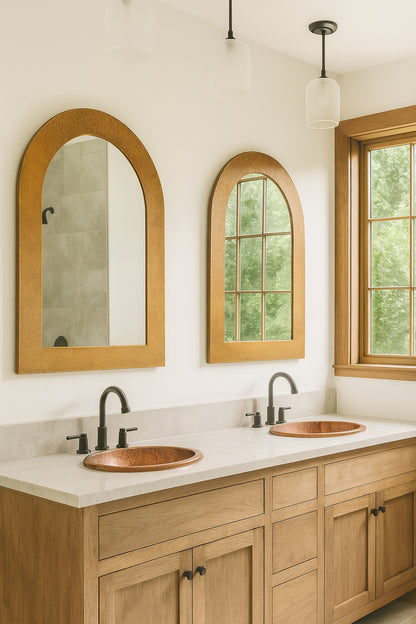 Two custom hand-hammered arched copper mirrors in a bathroom