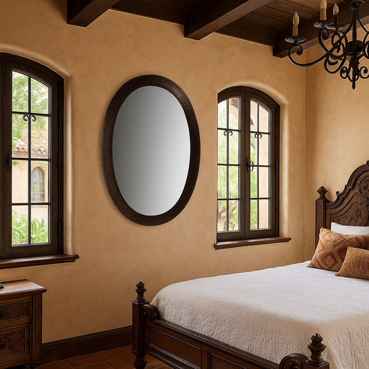 custom oval copper mirror in a Spanish Revival style bedroom