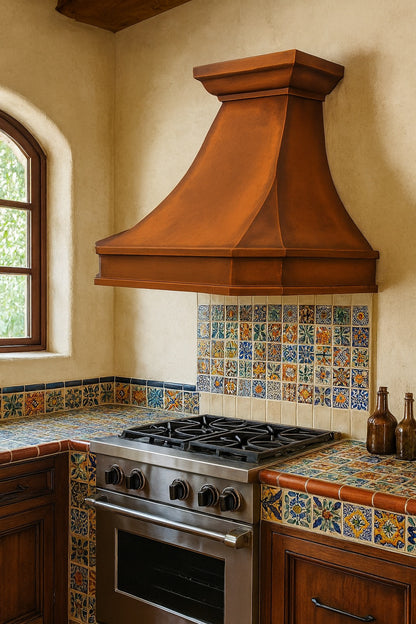 Hammered hacienda copper range hood with bold apron in a Spanish revival style kitchen