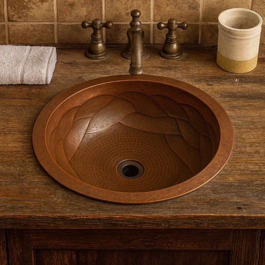 Custom round copper drop In sink with braided relief interior in a rustic bathroom