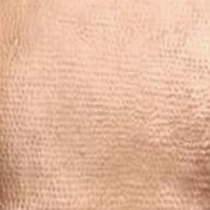 detail view of a kitchen sink with an apron hand hammered from copper